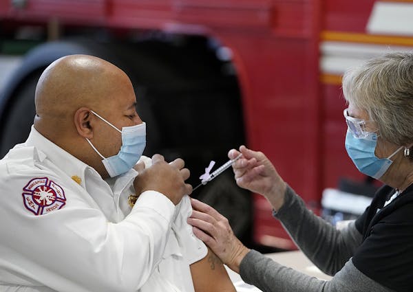 Minneapolis Fire Chief Bryan Tyner received his first COVID-19 vaccination from nurse Mary Greer of Hennepin Health on Tuesday at the Emergency Operat