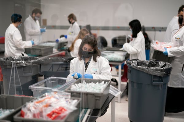 Alison Barnes decontaminated incoming saliva sample tubes as they arrive at the IBX processing area in this Oakdale, Minnesota facility.