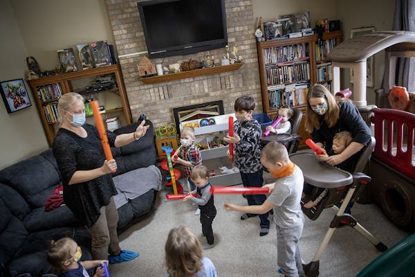 In-home child provider Kim Mueller, right, participated in a music session in which she hired Cindi Gervais, cq, left, of “Growing with Music,” as