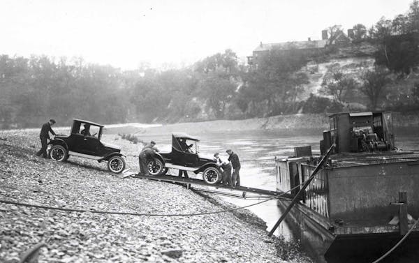 Ford cars built at the St. Paul plant are loaded on to river barges on the Mississippi River in 1925.