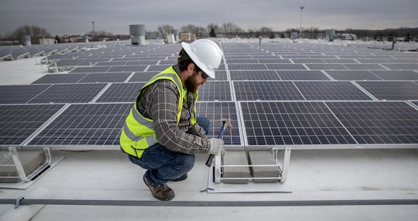 Cedar Creek Energy crew, including Reed Martin, installed solar panels on the roof of Brin Glass, Monday, April 6, 2020 in Fridley, MN. ELIZABETH FLOR