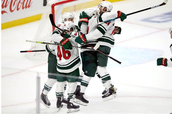 Wild defenseman Mathew Dumba, right, leaps into the arms of left wing Kirill Kaprizov, second from right, after an overtime goal against the Los Angel