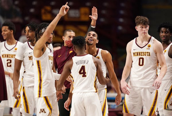 Gophers guards Tre’ Williams (1) and Jamal Mashburn Jr. (4) celebrated after beating Michigan on Saturday.