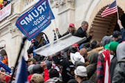 Demonstrators steal a Metropolitan Police riot shield while attempting to enter the U.S. Capitol building in Washington, D.C., on Jan. 6, 2021. MUST C