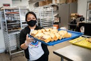 Cashier Yolanda Saaveda filled the shelves at Los Hornos del Rey with baked goods at Highland Plaza in Minneapolis on Thursday.