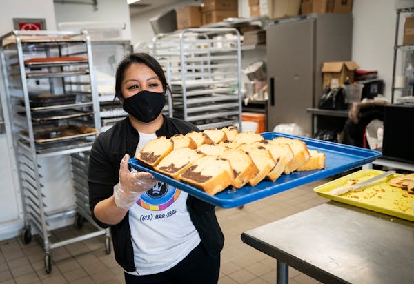 Cashier Yolanda Saaveda filled the shelves at Los Hornos del Rey with baked goods at Highland Plaza in Minneapolis on Thursday.