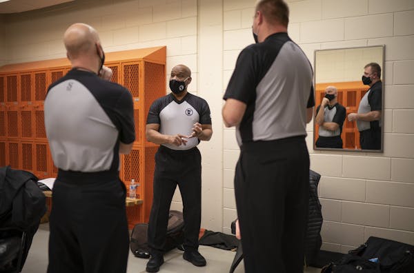 Crew Chief Lamarr Sullivan went over the plan for officiating a game between Anoka and Osseo with his colleagues Denny Misener, left, and Kevin Markli