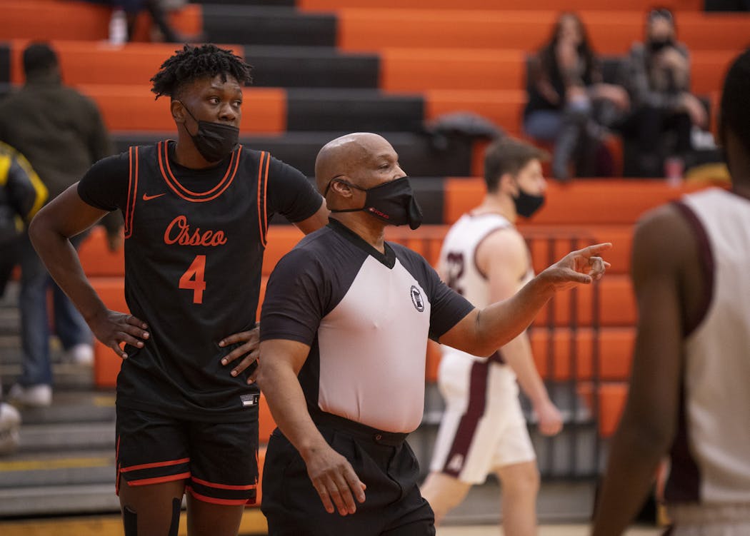 Referee Lamarr Sullivan followed up after after he made a call that Osseo’s Josh Ola-Joseph (4) was fouled by an Anoka player in the first half. The mask he is wearing accommodates the whistle he keeps in his mouth while officiating.
