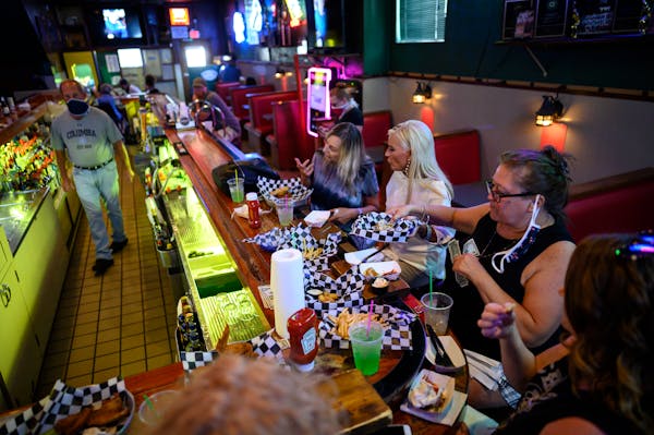 A group of regulars, mostly from Robbinsdale, drank and ate dinner at the bar at Tony Jaros River Garden in the summer.