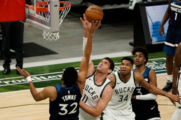 Milwaukee’s Brook Lopez blocks a shot by Timberwolves center Karl-Anthony Towns during the first half Tuesday. 