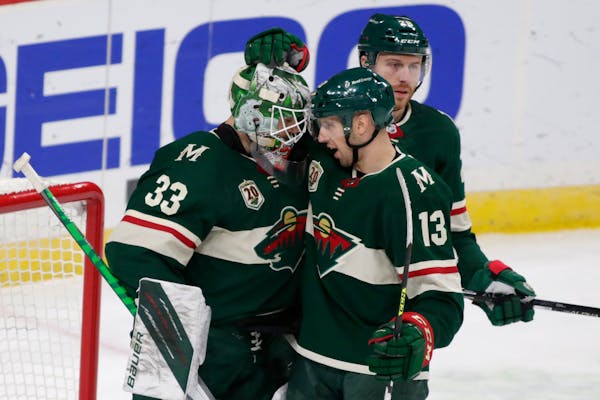 Minnesota Wild goalie Cam Talbot (33) is congratulated by center Nick Bonino (13) after defeating the Los Angeles Kings in an NHL hockey game, Friday,