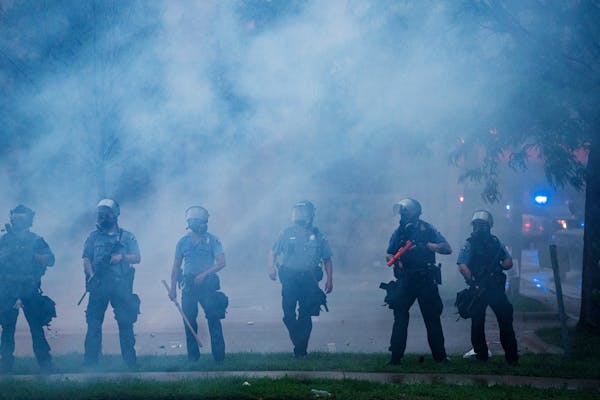 Police officers deployed to disperse protesters gathered for George Floyd in Minneapolis on Tuesday, May 26, 2020. During the rioting last year, metro