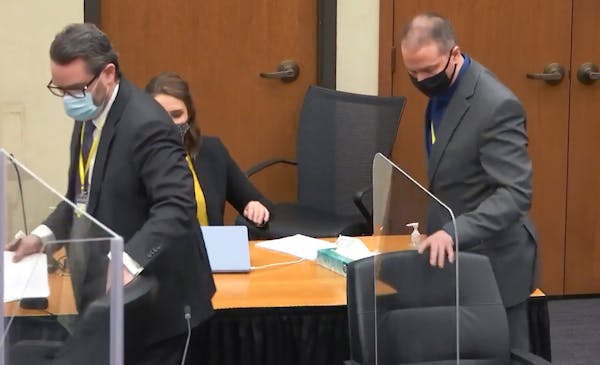 In this image taken from video, defense attorney Eric Nelson, left, and defendant former Minneapolis police officer Derek Chauvin take their seats aft