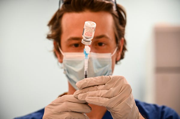 Kirk Randall, a nurse with Blue Cross and Blue Shield of Minnesota, filled a syringe with a dose of the Moderna COVID-19 vaccine on March 9.