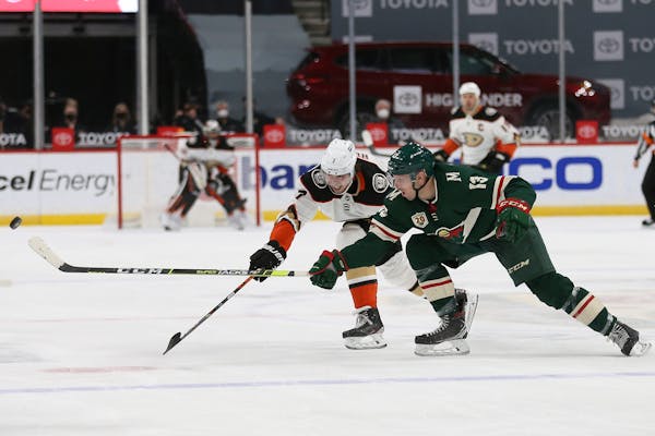 Anaheim’s Ben Hutton (7) and the Wild’s Nick Bonino (13) go after the puck during the second period on March 22