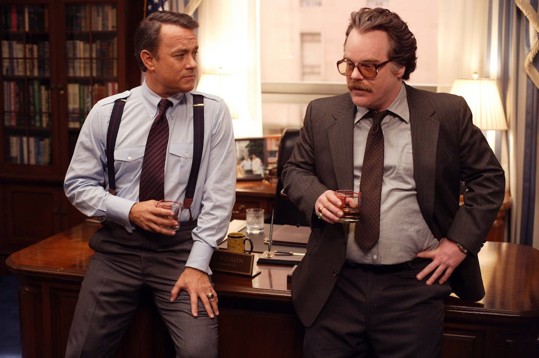 Tom Hanks as Charlie Wilson and Philip Seymour Hoffman as Gust Avrakotos.