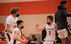 Maple Grove Crimson forward Lincoln Palbicki (55), guard Andy Tran (15), and guard Jon Haakenson (2) celebrated at the buzzer after they upset Champli