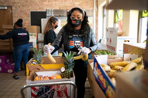 Bridgett Floyd and members of Visual Black Justice helped pack produce boxes for families at a Salvation Army location on Lake Street on Thursday, Apr