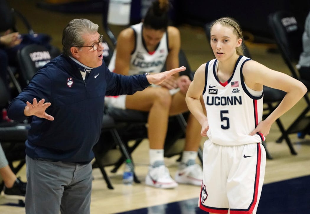Connecticut head coach Geno Auriemma talks with Paige Bueckers during a game last month.