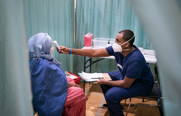 Paramedic Kayse Abdirahman checked Milgo Ahmed’s temperature before administering the vaccine last Friday.