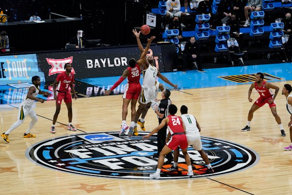 Houston forward Reggie Chaney (32) fights for the opening tipoff with Baylor forward Flo Thamba (0) Saturday