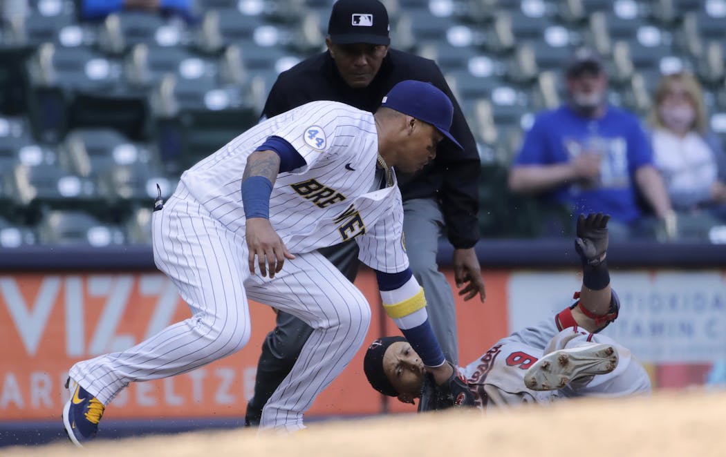 Andrelton Simmons managed to elude Orlando Arcia’s tag at third base, although umpire C.B. Bucknor initially ruled him out.