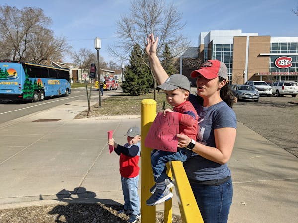 Heather Mayer of St. Cloud and sons Finley, 5, and Emmett, 2, send off the St. Cloud State men’s hockey team as it departs for the Frozen Four on Mo