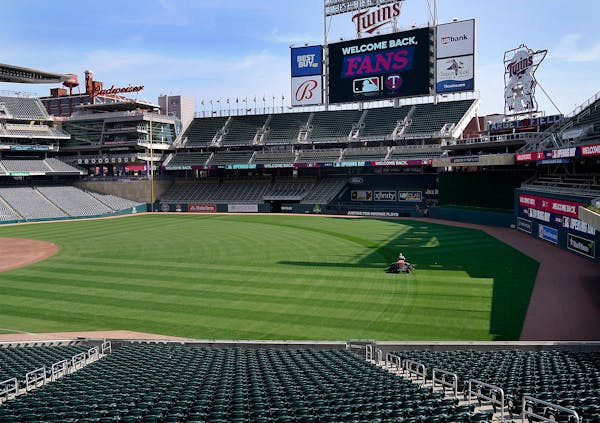 Grounds crew members prepare Target Field for the April 8 home opener 