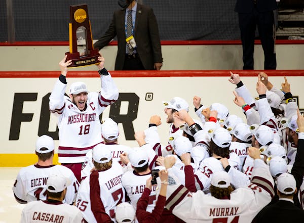Massachusetts forward Jake Gaudet yelled in celebration while holding the NCAA men’s hockey national championship trophy 