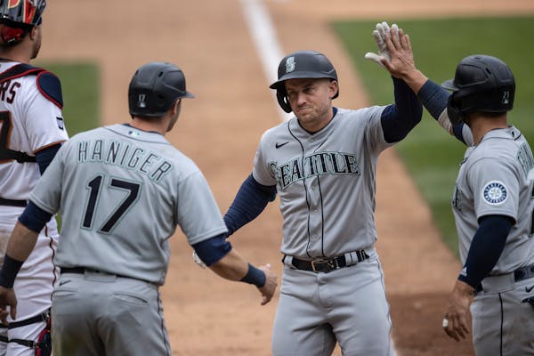 Seattle third baseman Kyle Seager (15) celebrated his three-run homer in the ninth inning with Mitch Haniger, left, and Ty France.