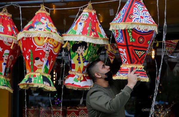 A Palestinian shopkeeper hangs Ramadan lanterns ahead of the Muslim fasting month of Ramadan, in the West Bank city of Nablus in 2021