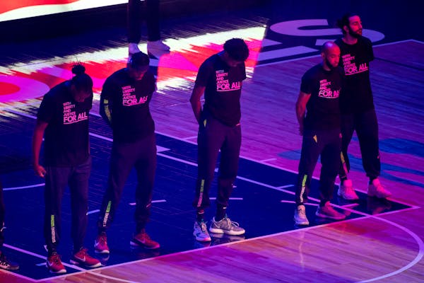 Members of the Timberwolves and the Brooklyn Nets wear T-shirts that read “With liberty and justice for all” as a tribute to Daunte Wright, before