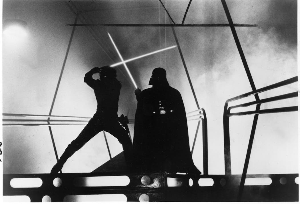 Luke Skywalker (played by Mark Hamill, at left) battles Darth Vader (played by David Prowse, right).