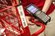 A Target employee at the Nicollet Mall store holds a device used to identify items bought online. The order was being fulfilled in the store.  (Courtn