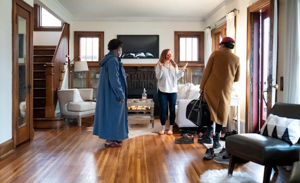 Real estate agent Leah Drury greeted prospective buyers as they arrived at an open house she held Wednesday evening in South Minneapolis .       ] GLE