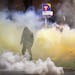 A demonstrator walked amid the tear gas emitted from canisters outside the Brooklyn Center Police Department Sunday night.     ]  JEFF WHEELER • jef