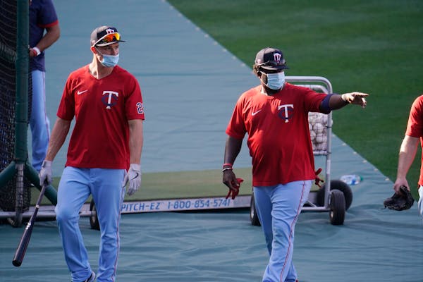 Twins players wear masks during batting practice amid the COVID-19 pandemic, before a game against the Angels on Friday
