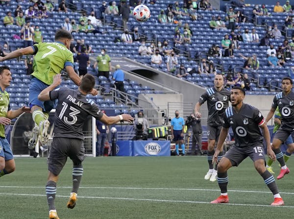 Seattle midfielder Cristian Roldan (7), checked by the Loons’ Ethan Finlay, hit a header Friday during the Sounders’ 4-0 victory in the season ope