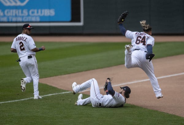 Twins first baseman Willians Astudillo (64) jumped over teammate right fielder Jake Cave (60) after he caught a foul ball hit by Pittsburgh’s Erik G