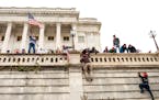 People climbed a wall of the Capitol in Washington during an attack on the building Jan. 6, 2021.