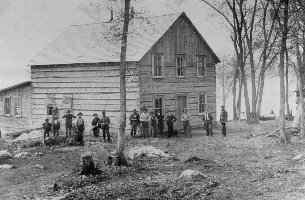 People stand outside the The Green Tree Hotel at Rainy Lake during the gold rush there in the late 1800s.