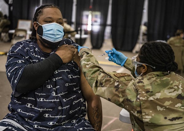Michael Elder of St. Paul got a COVID-19 vaccine shot last month from Lydia Payne, a senior airman in the Air Force, at the Minnesota State Fairground