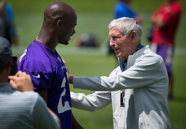 Former Vikings head coach Jerry Burns greets Adrian Peterson after a practice in 2015.