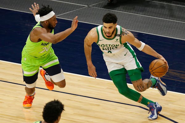 Boston Celtics forward Jayson Tatum (0) drives on Minnesota Timberwolves forward Josh Okogie (20) in the first quarter during an NBA basketball game, 