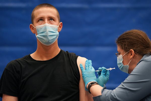 Hayden Ring, 21, a junior studying management and psychology, looked up as he got his second dose of the Pfizer COVID-19 vaccine from Karla Marz, a ph