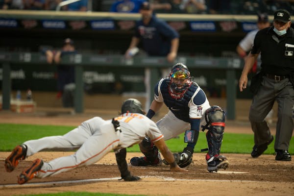 Twins catcher Mitch Garver waiting at home to tag out the Orioles’ Cedric Mullins, trying to score on a Freddy Galvis double in the seventh inning M