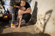 in disrepair: Rachel Jones, with her sons, 20-month-old Rhys Belknap and 3-year-old Finn Belknap, showed her crumbling basement wall.