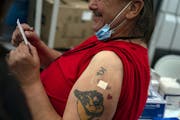 Kenneth Bennett, 54, holds his vaccination card after receiving a dose of COVID-19 vaccine at a mobile vaccination site in Seattle on May 17, 2021. Mo