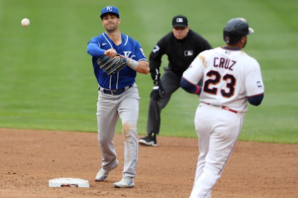 The Royals’ Whit Merrifield threw to first after forcing out the Twins’ Nelson Cruz to complete a double play in the fifth inning Sunday.