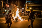 Protesters set a dumpster on fire and added other items to it late Thursday night in Minneapolis’ Uptown neighborhood.